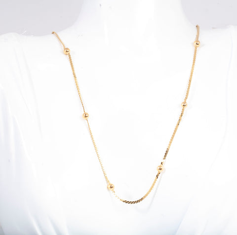 Gold necklace on a mannequin with a white background